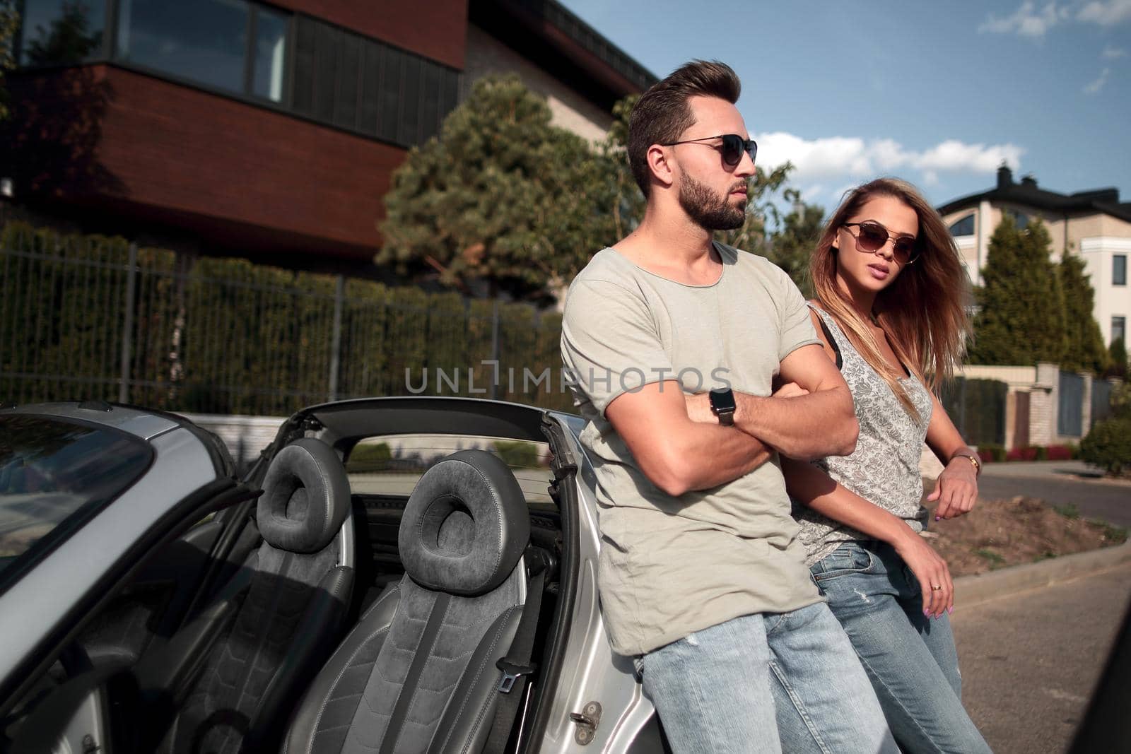 young couple standing near luxury car. by asdf