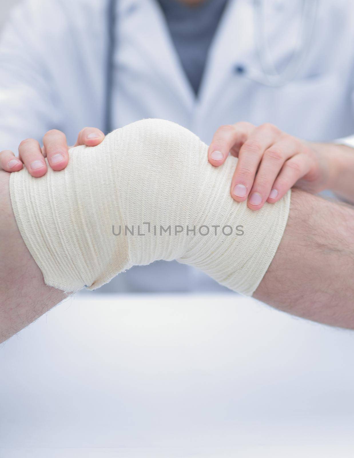traumatologist ,applying a bandage on the knee by asdf