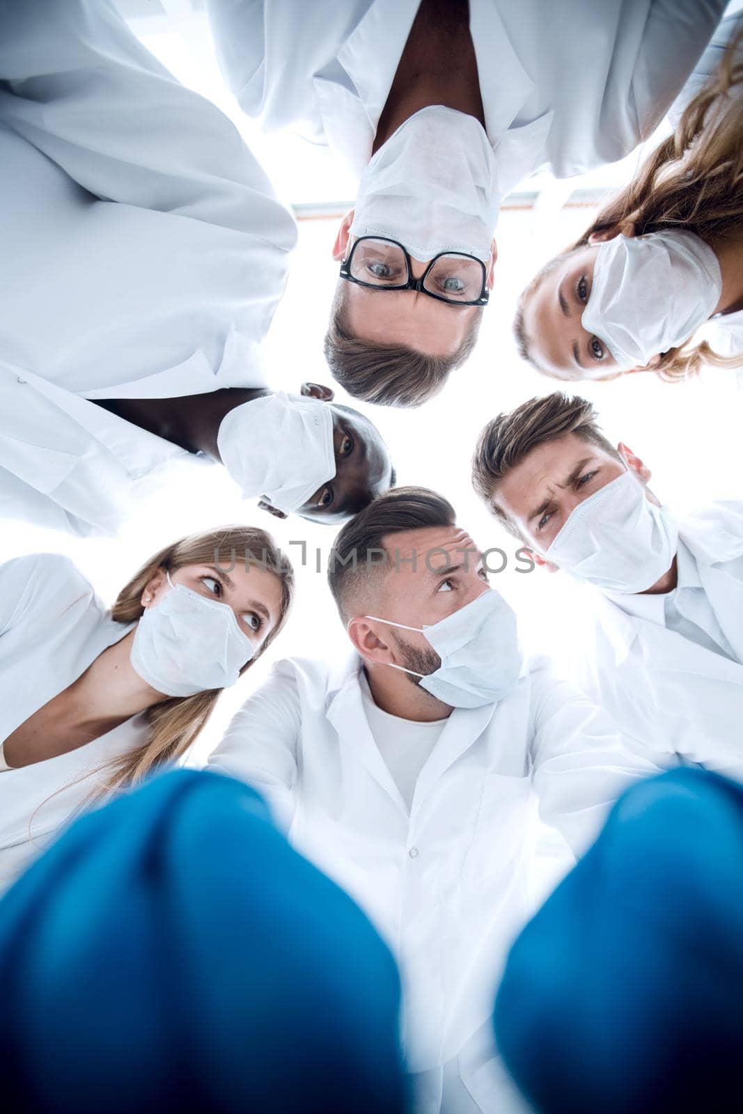 Large diverse multiethnic medical team standing grouped circle all looking down