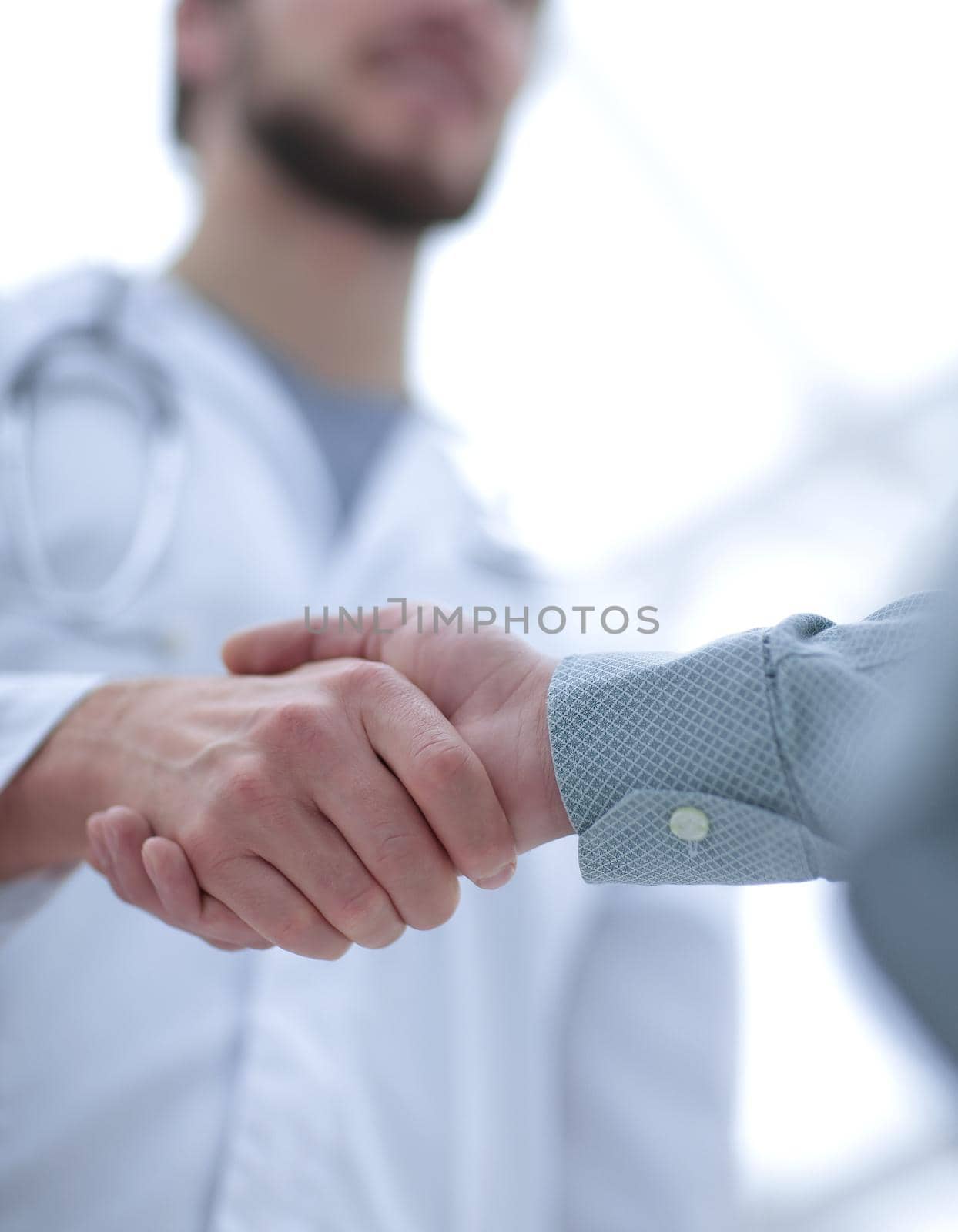 closeup.handshake between doctor and patient. by asdf