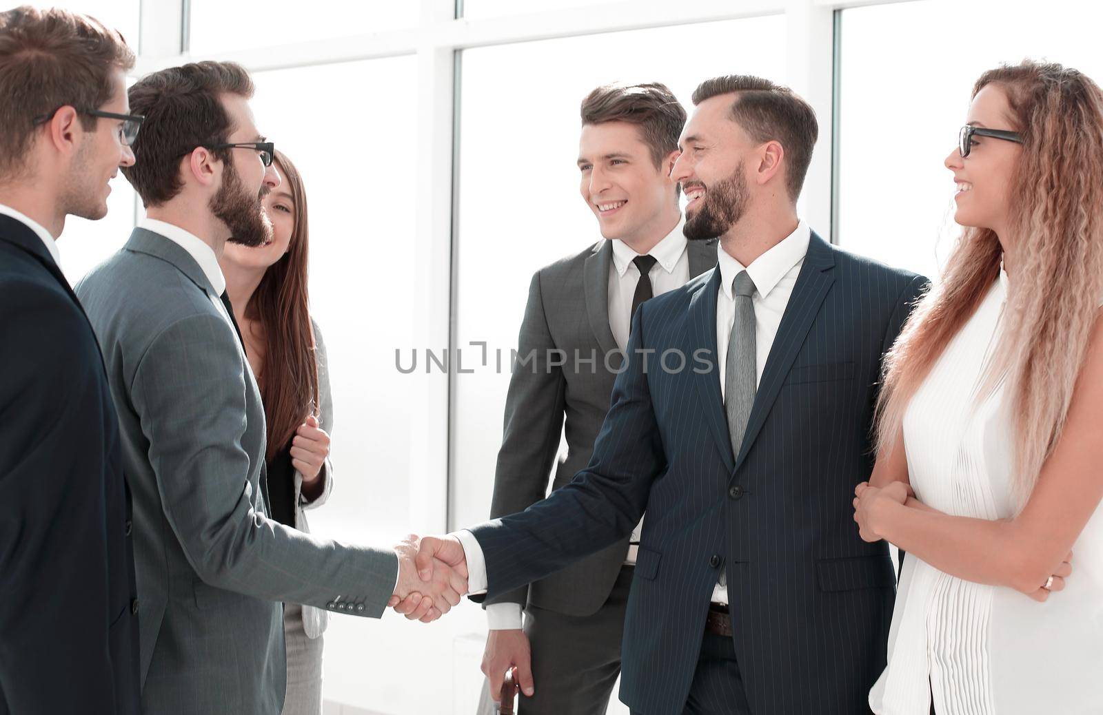 employees greet each other with a handshake by asdf