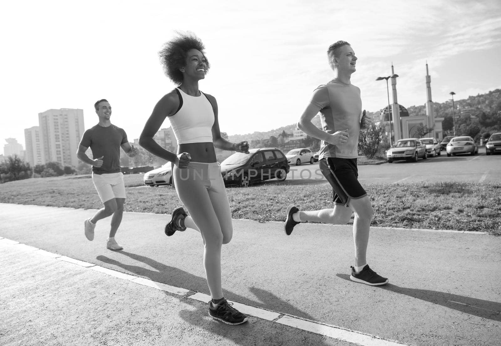 multiethnic group of young people on the jogging beautiful morning as the sun rises in the streets of the city