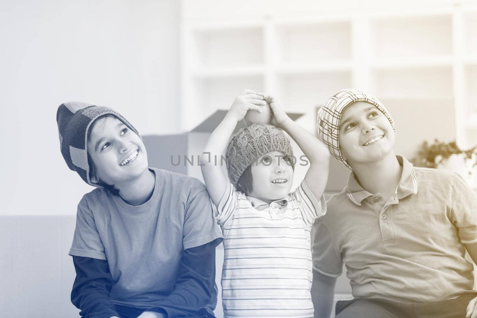 portrait of happy young boys with cardboard boxes around them in a new modern home