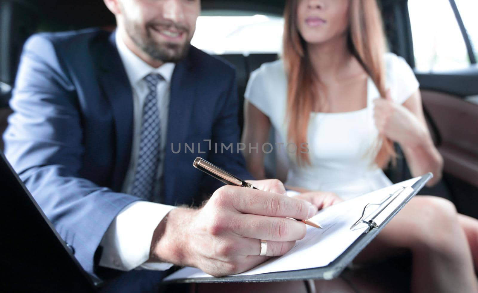 Male employee with digital tablet and pen communicating with colleague