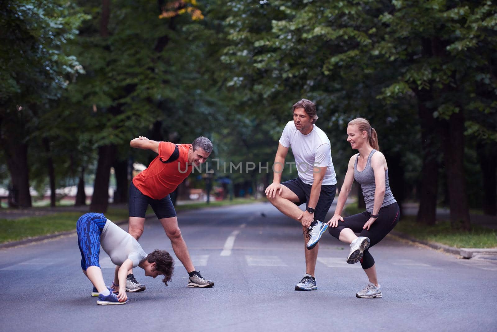 jogging people group stretching in park before training