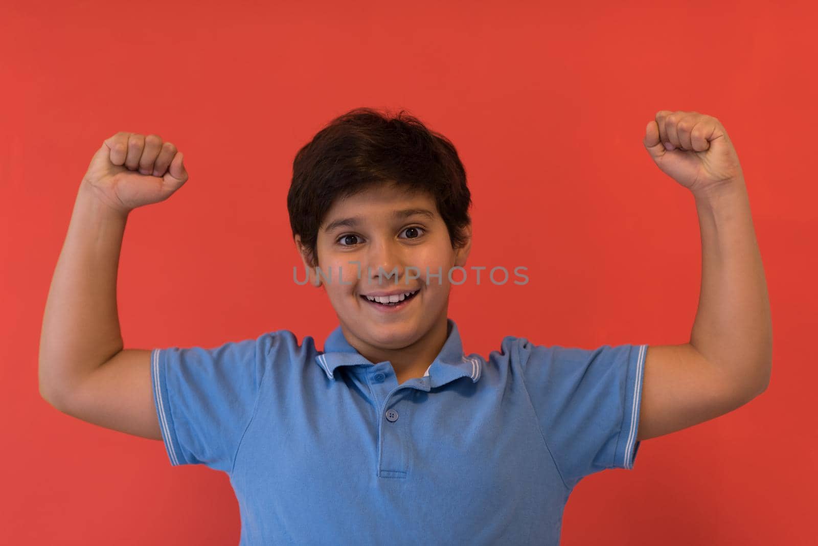 Portrait of a happy young boy in front of colored background