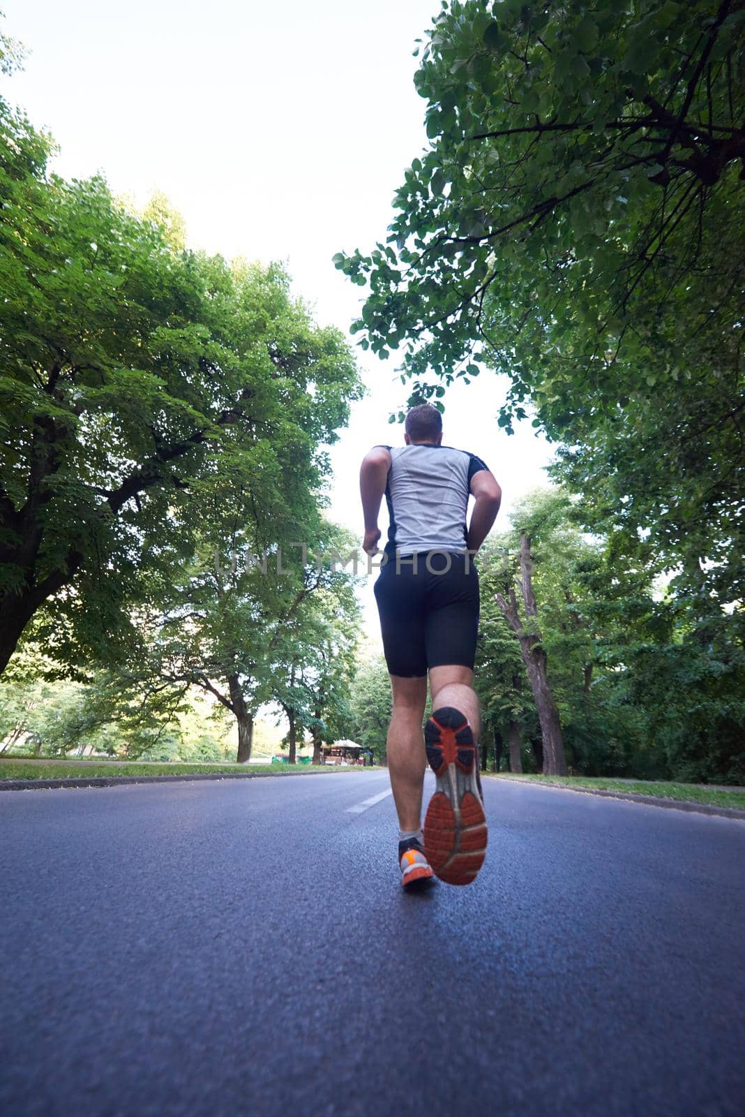 healthy athlete man jogging at morning on empty  roat in the city