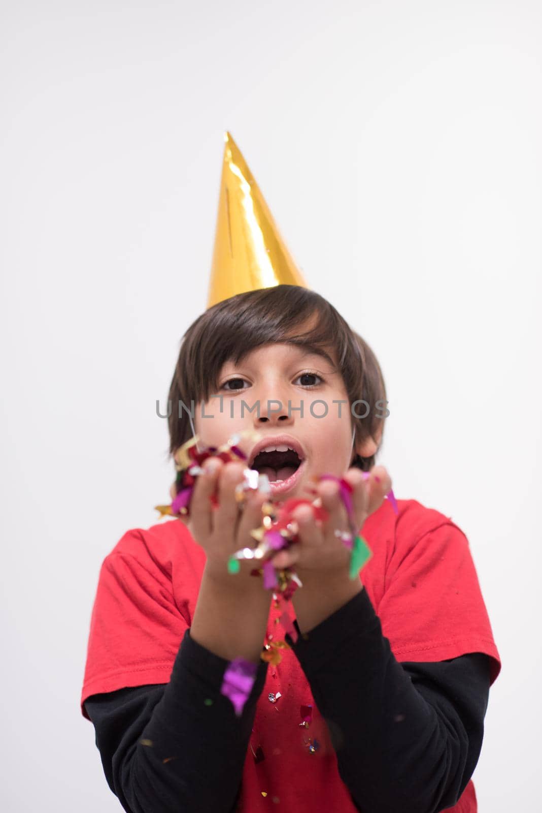Happy kid celebrating party with blowing confetti