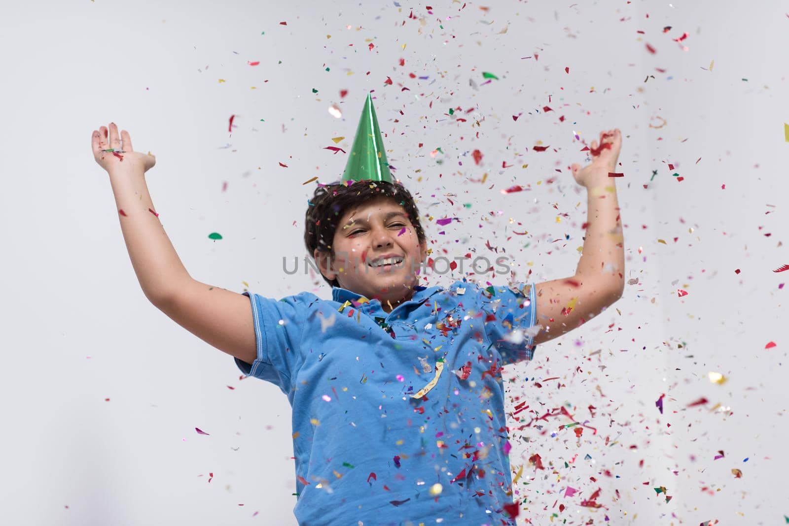 Happy kid celebrating party with blowing confetti