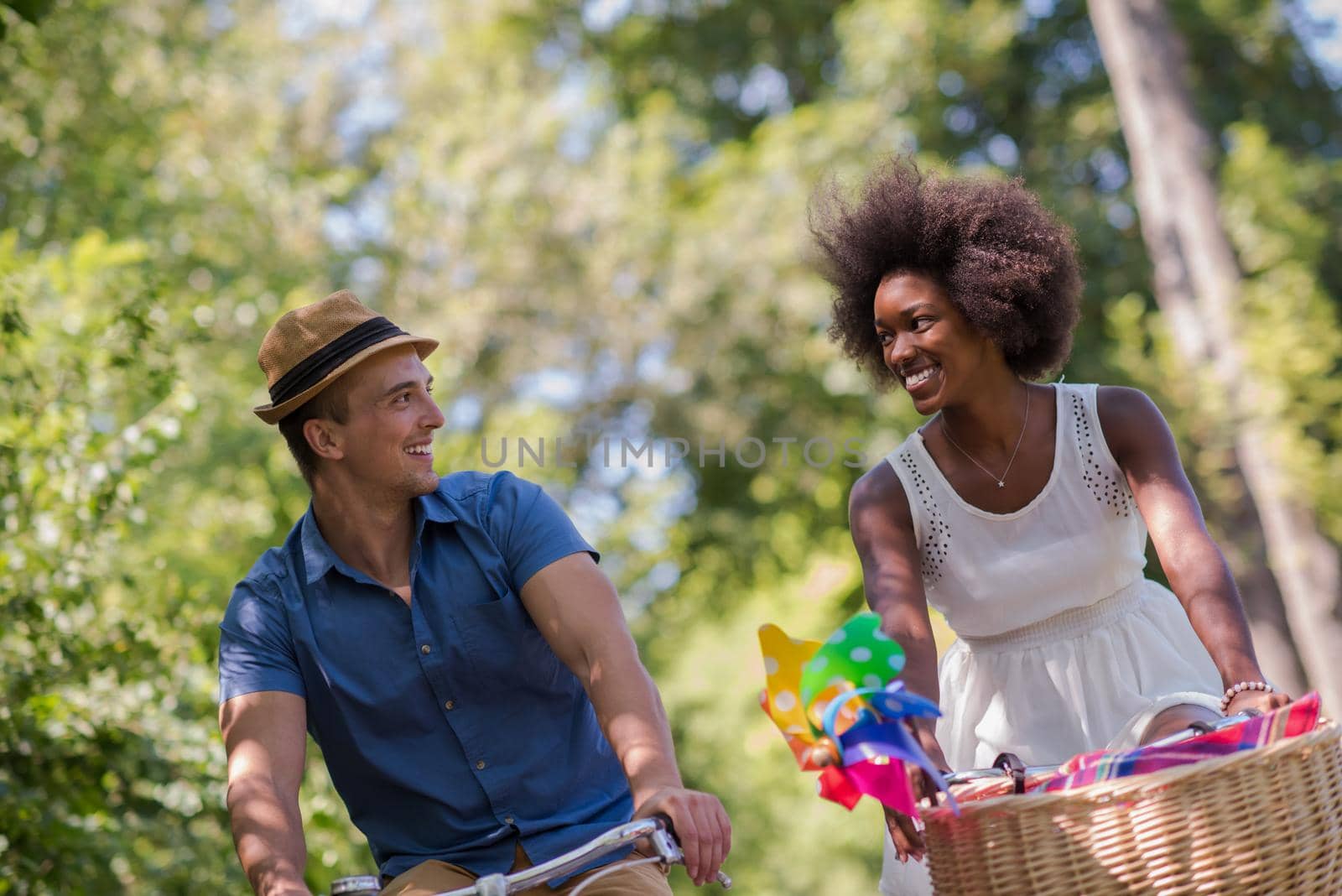 a young man and a beautiful African American girl enjoying a bike ride in nature on a sunny summer day