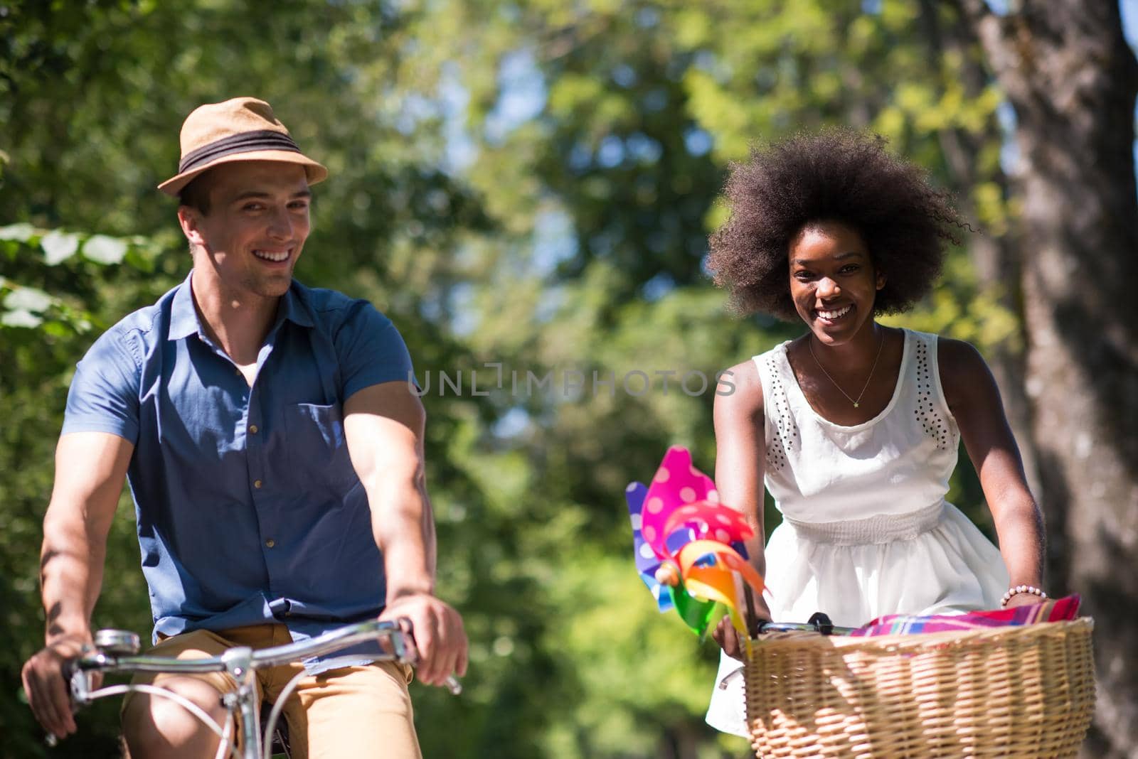 a young man and a beautiful African American girl enjoying a bike ride in nature on a sunny summer day