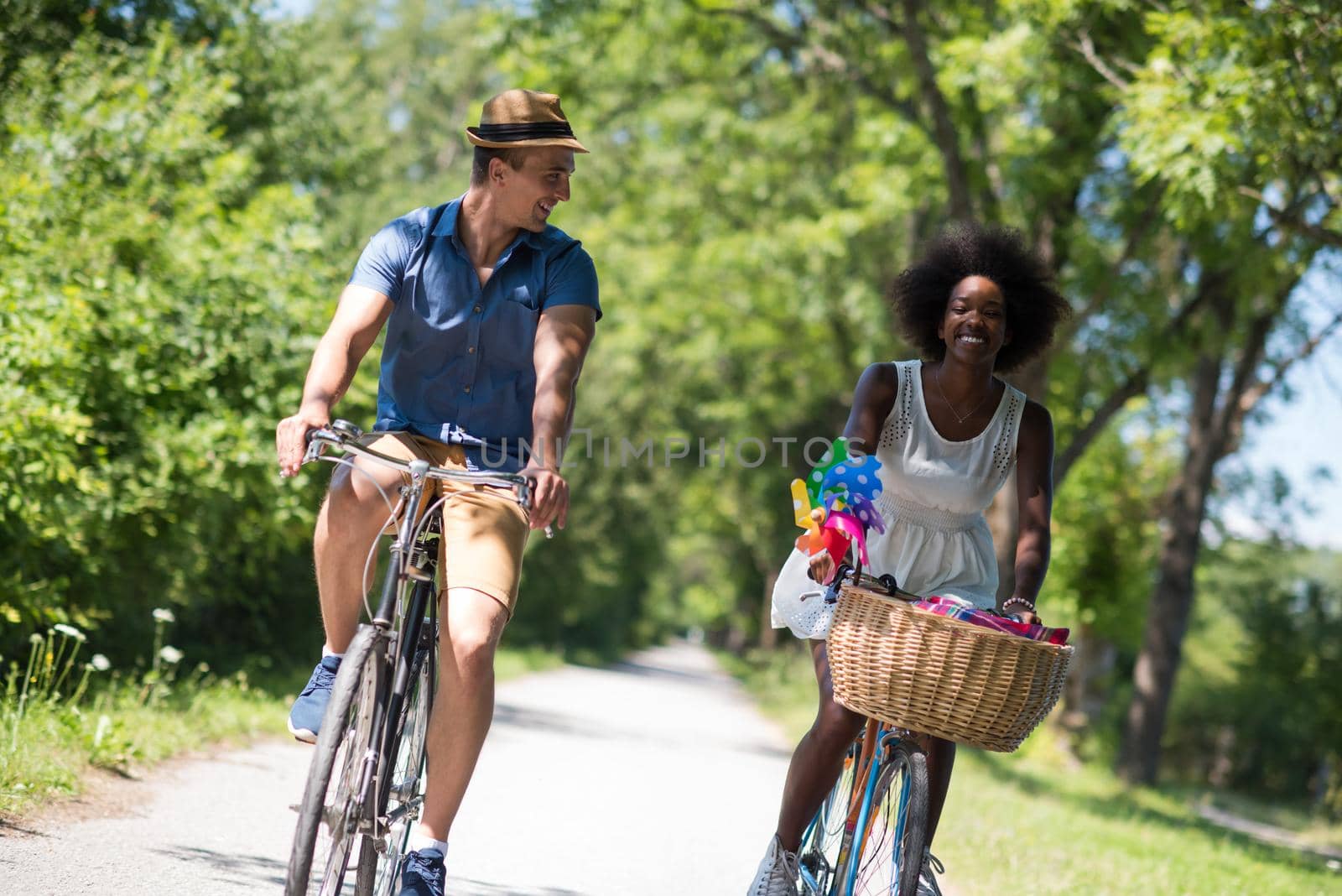 a young man and a beautiful African American girl enjoying a bike ride in nature on a sunny summer day