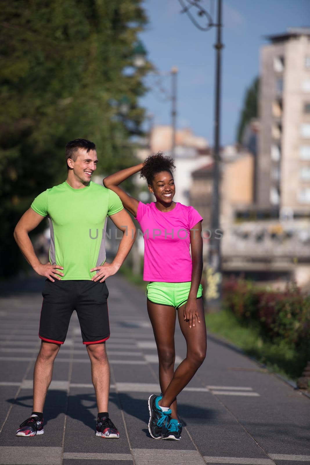 portrait of young multietnic jogging couple ready to run on fresh morning in the city