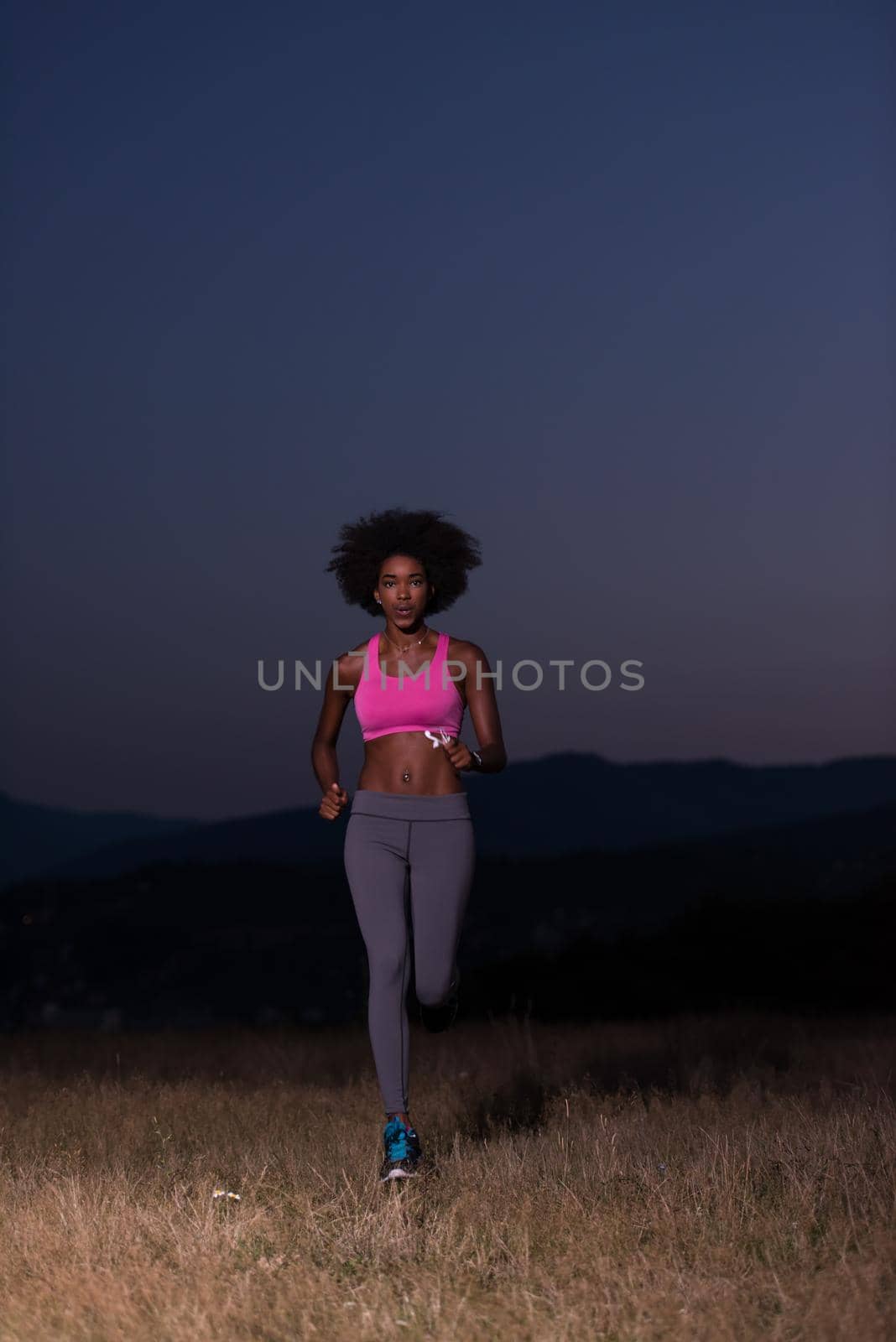 Young African american woman jogging in nature by dotshock