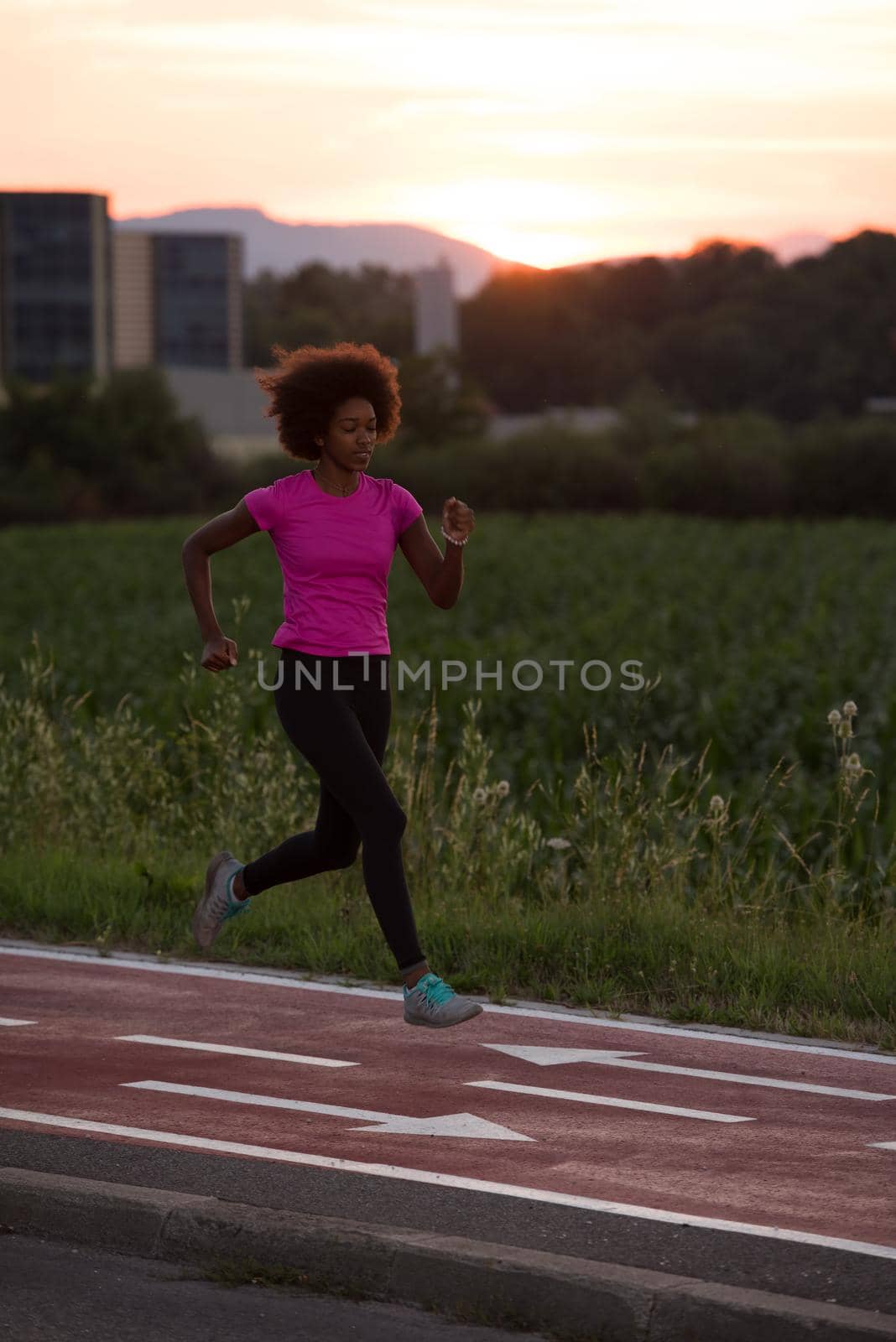 young beautiful African American woman enjoys running outside beautiful summer evening in the city