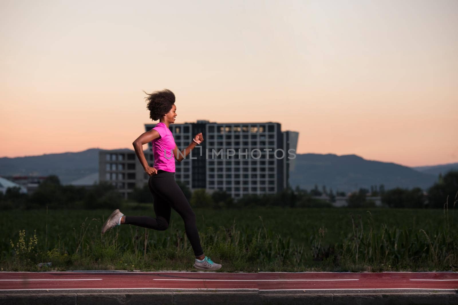 young beautiful African American woman enjoys running outside beautiful summer evening in the city