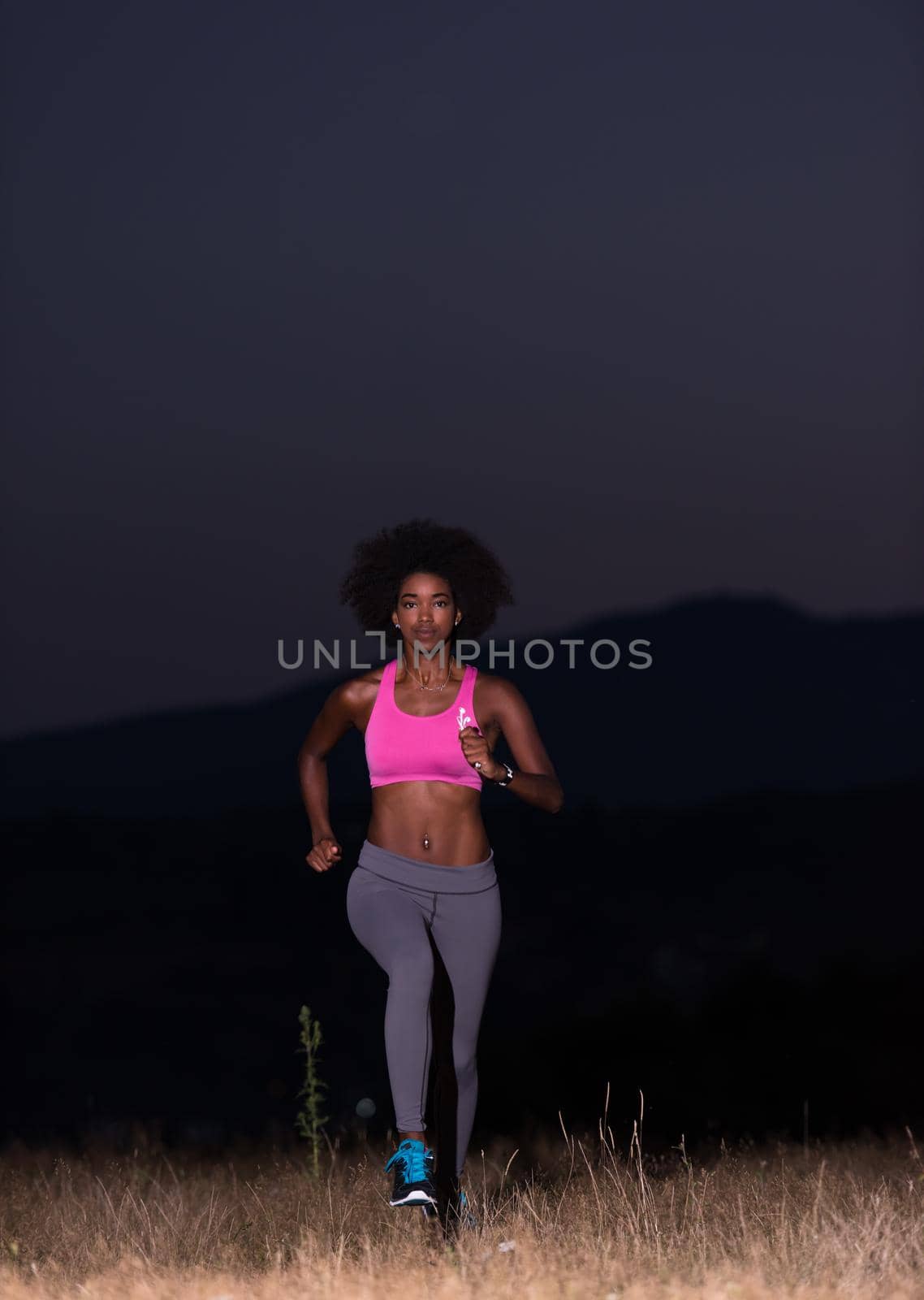 Young African american woman jogging in nature by dotshock