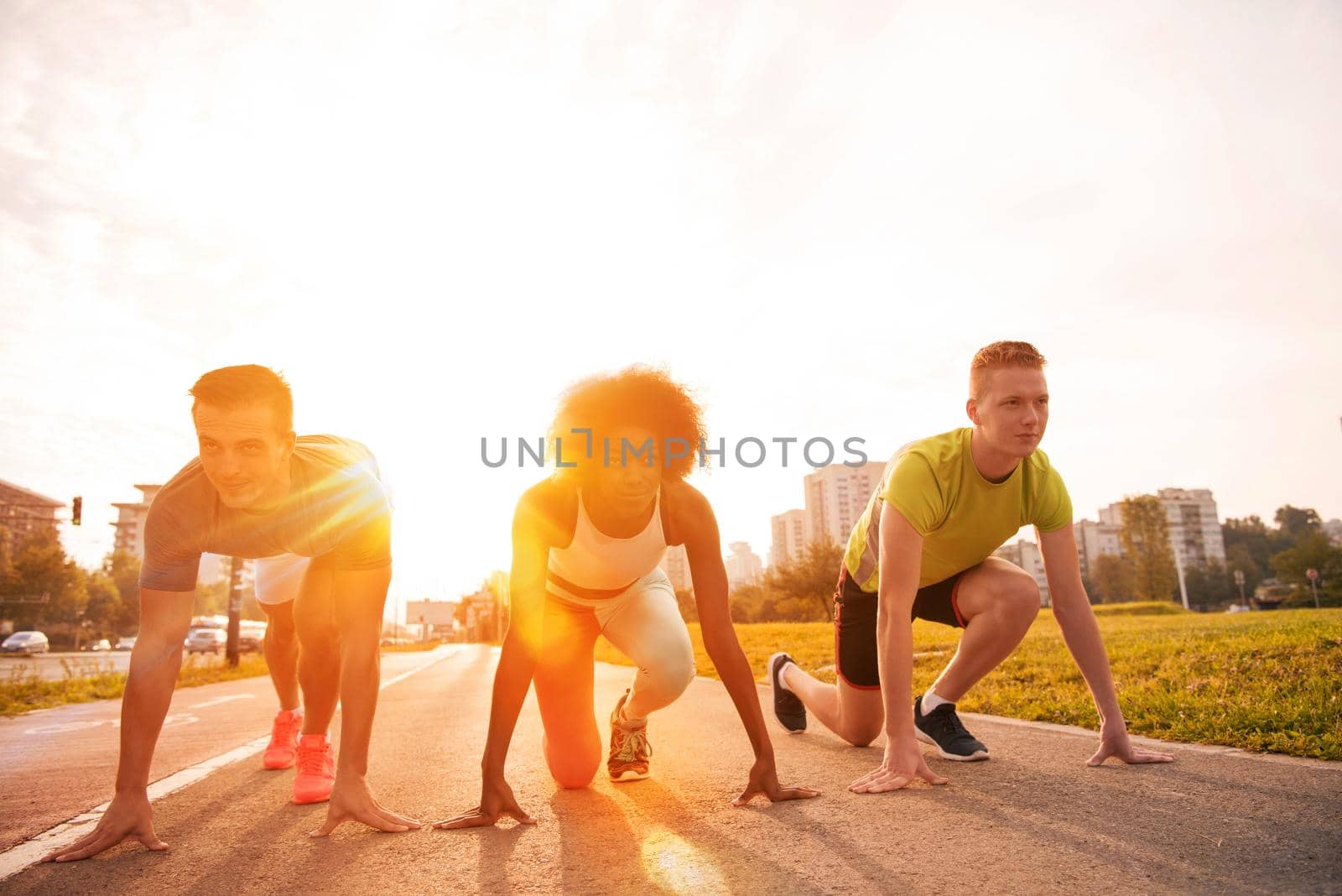 multiethnic group of young people on the jogging beautiful morning as the sun rises in the streets of the city