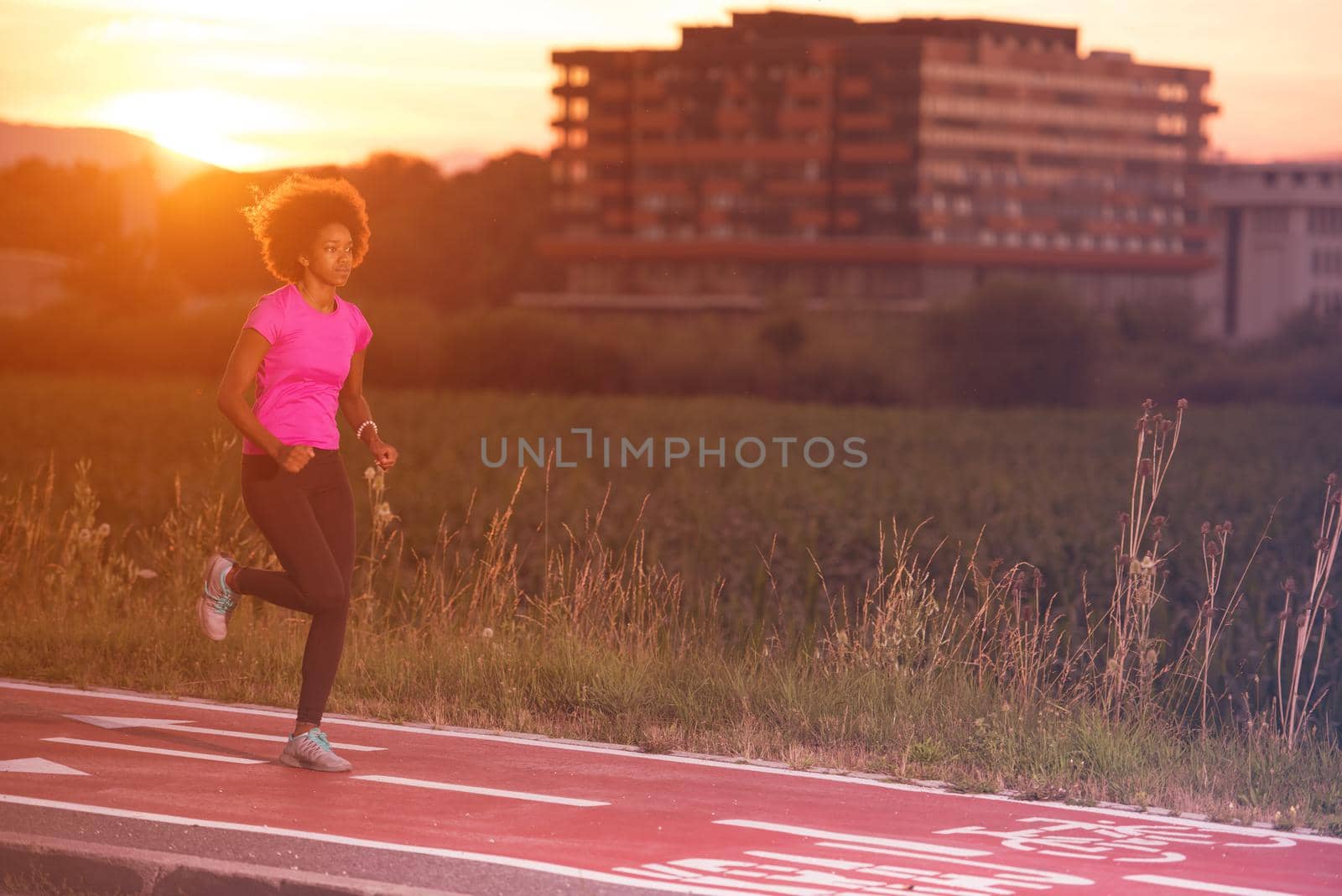 young beautiful African American woman enjoys running outside beautiful summer evening in the city