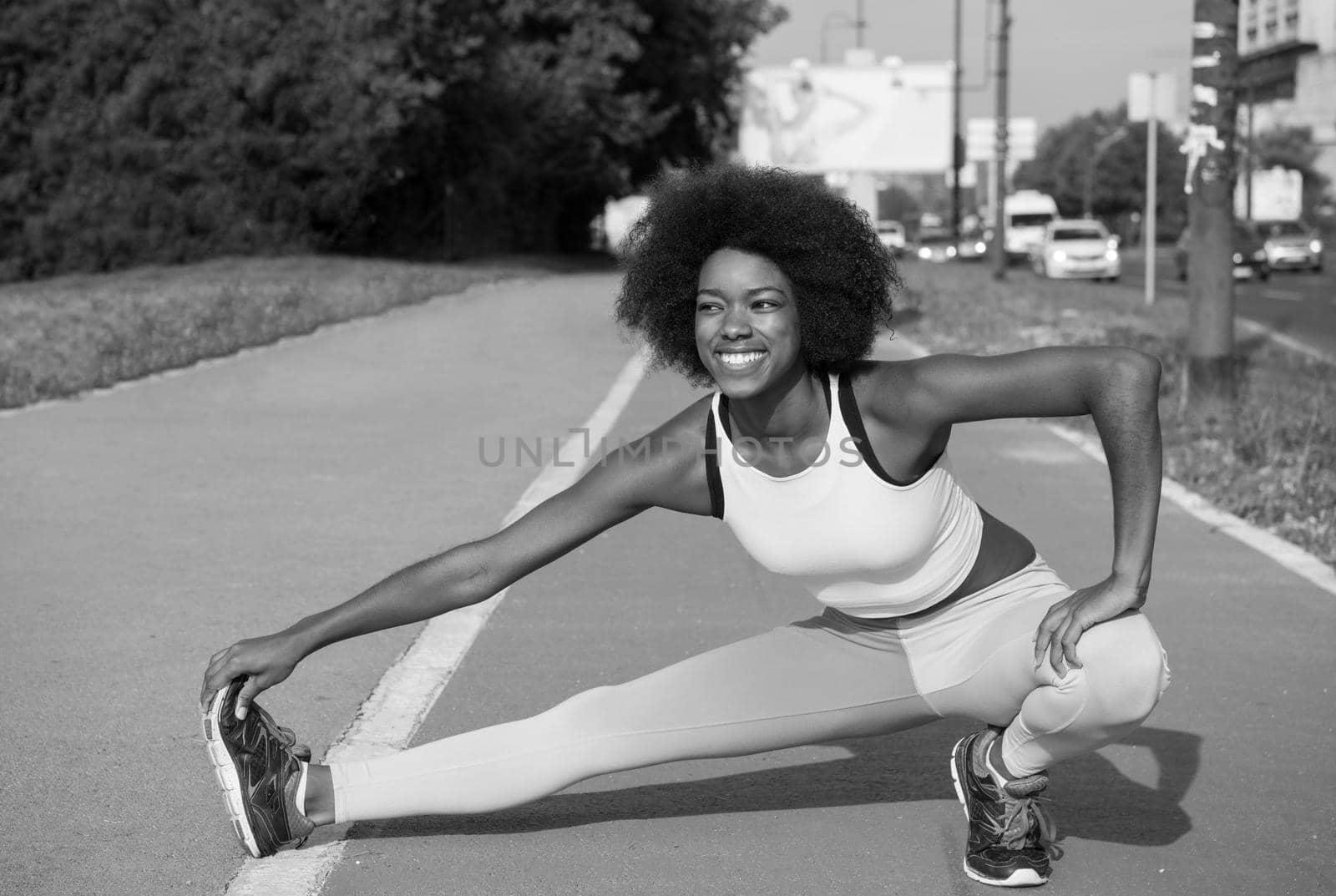 portrait of a young beautiful African American girl doing stretching beautiful summer morning on the streets of the city