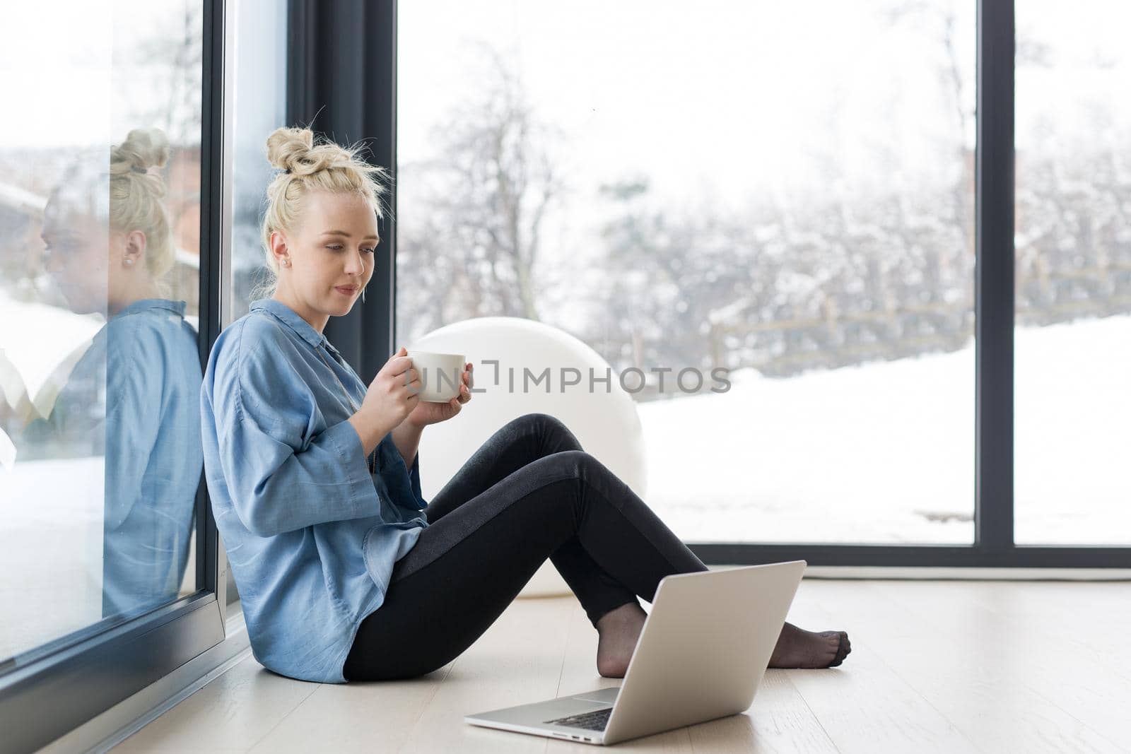 Real Woman Using laptop on the floor Drinking Coffee Enjoying Relaxing at cold winter day