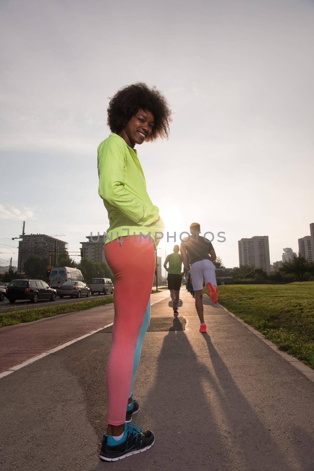 portrait of a young African American girl to run beautiful summer morning on city streets