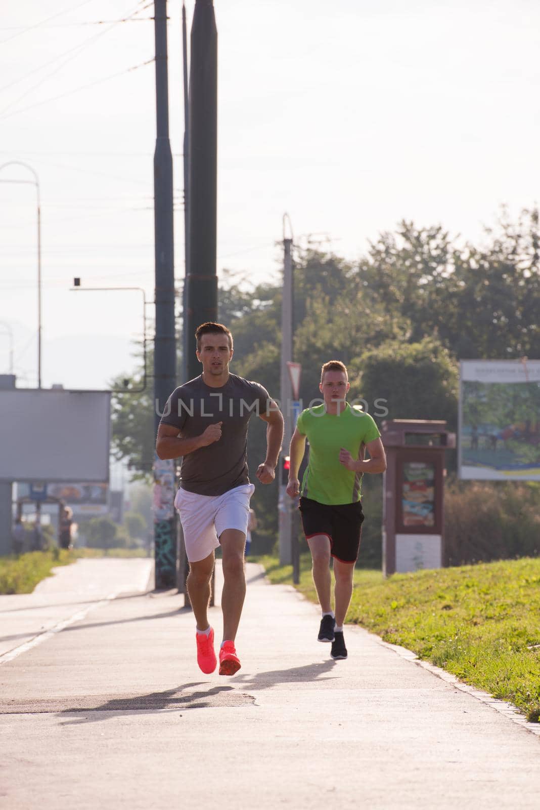 athletic young men enjoy running while the sun rises over the city