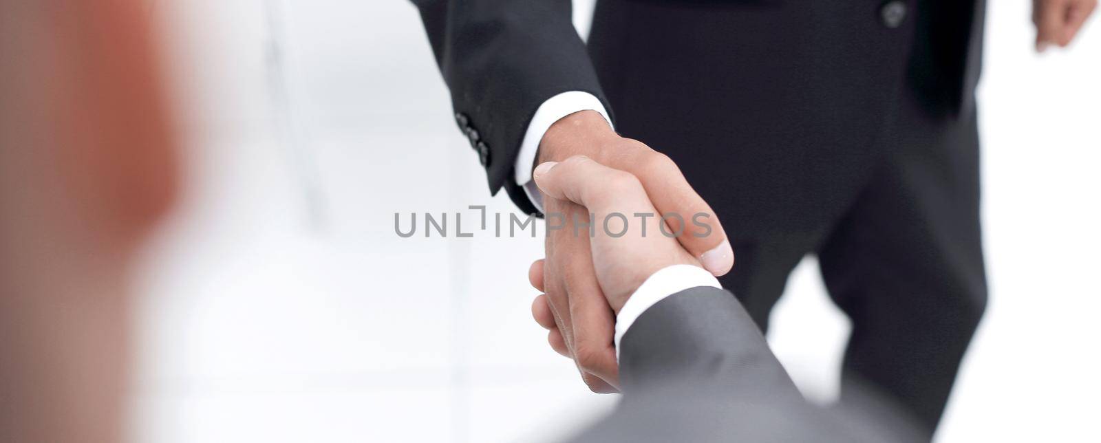 Cropped image of business people shaking hands in creative office