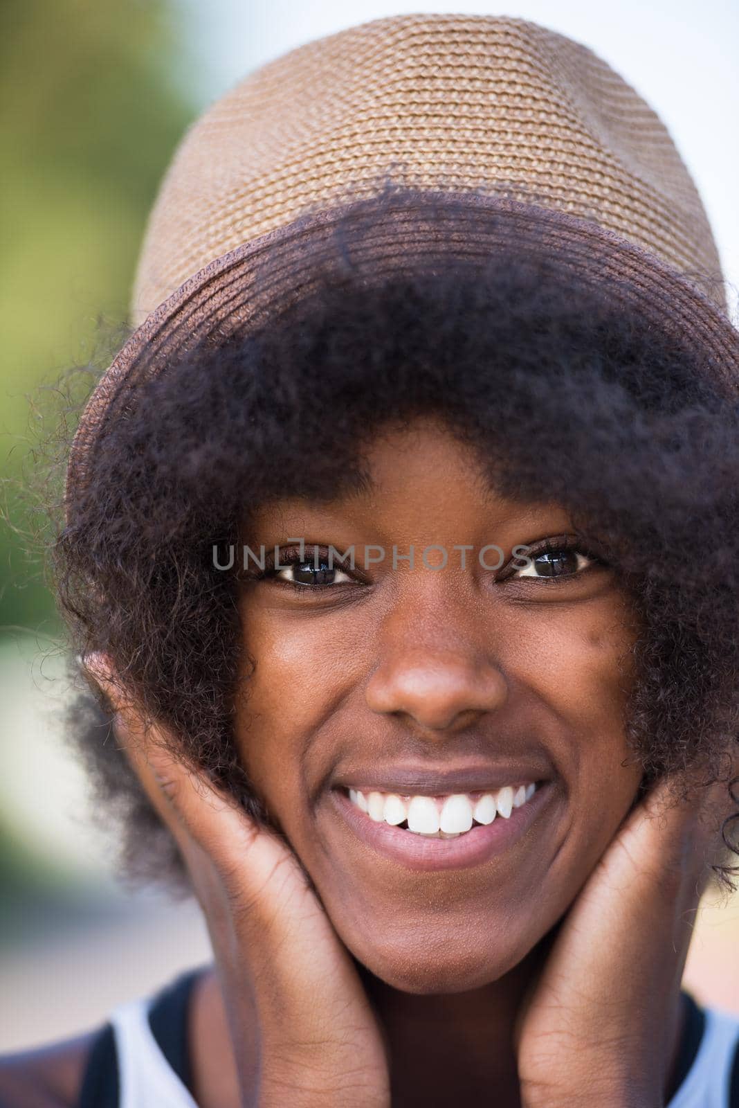 Close up portrait of a beautiful young african american woman smiling and looking up on a beautiful sunny day
