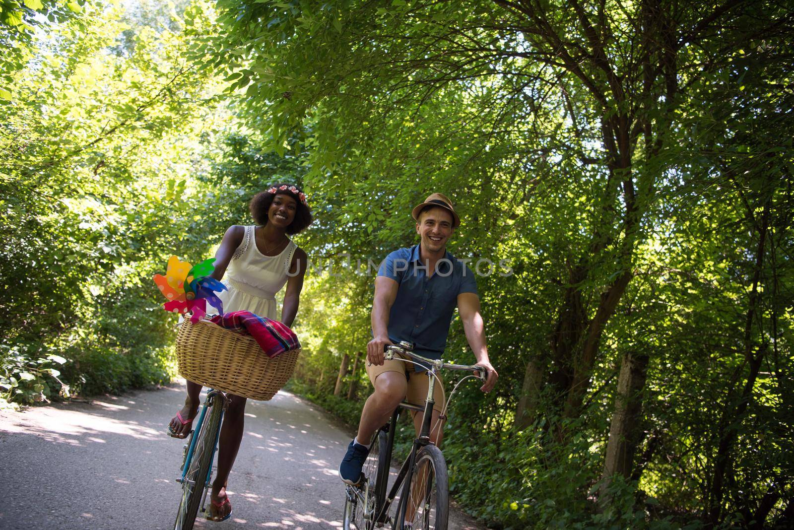 a young man and a beautiful African American girl enjoying a bike ride in nature on a sunny summer day