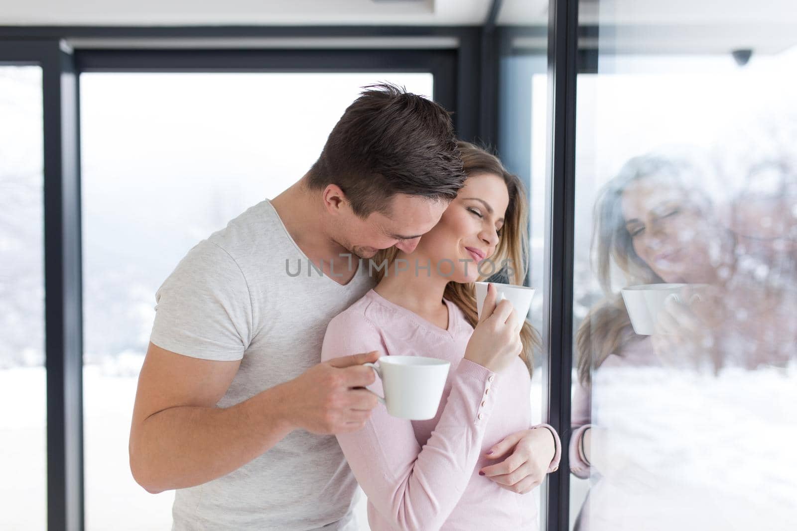 young couple enjoying morning coffee by the window by dotshock