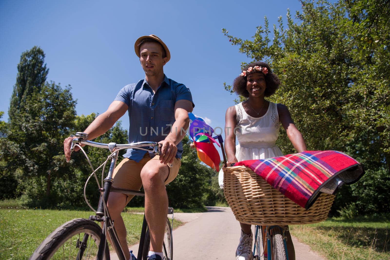 a young man and a beautiful African American girl enjoying a bike ride in nature on a sunny summer day