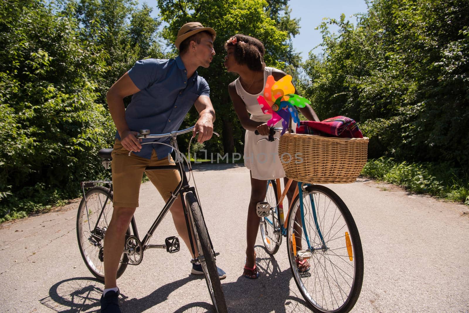 a young man and a beautiful African American girl enjoying a bike ride in nature on a sunny summer day