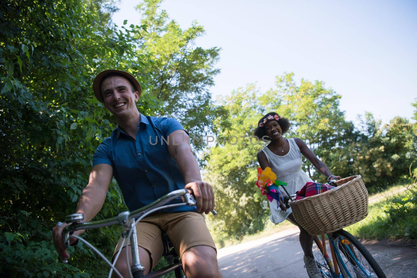 a young man and a beautiful African American girl enjoying a bike ride in nature on a sunny summer day