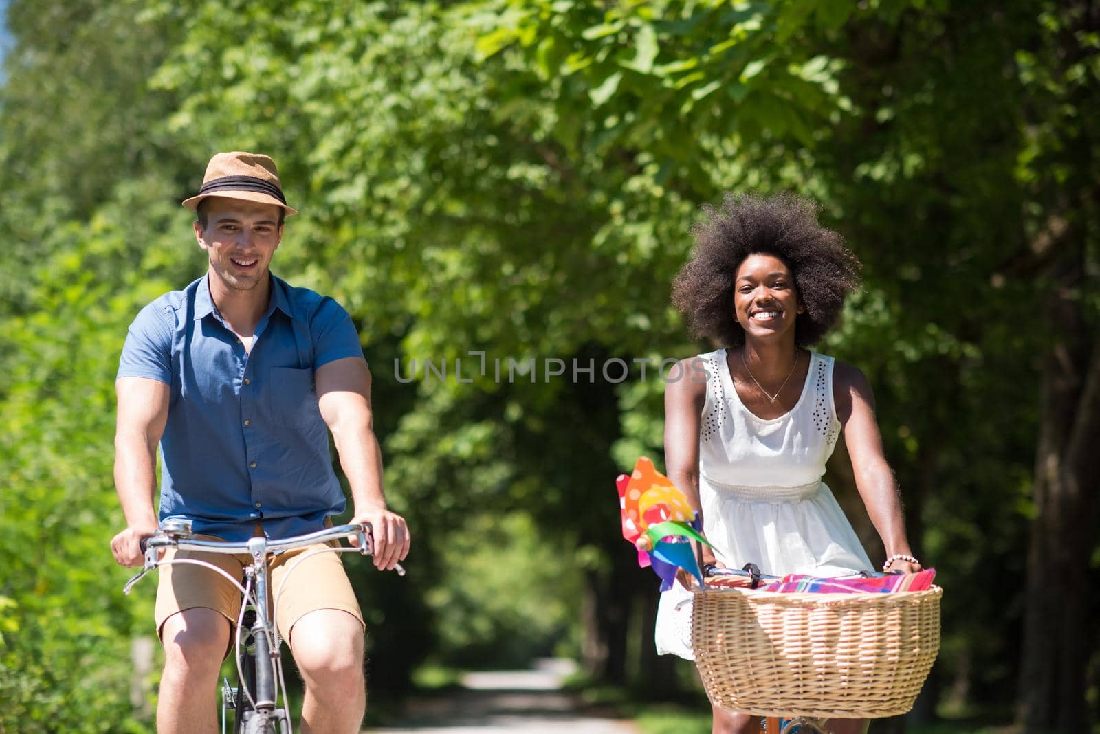 a young man and a beautiful African American girl enjoying a bike ride in nature on a sunny summer day