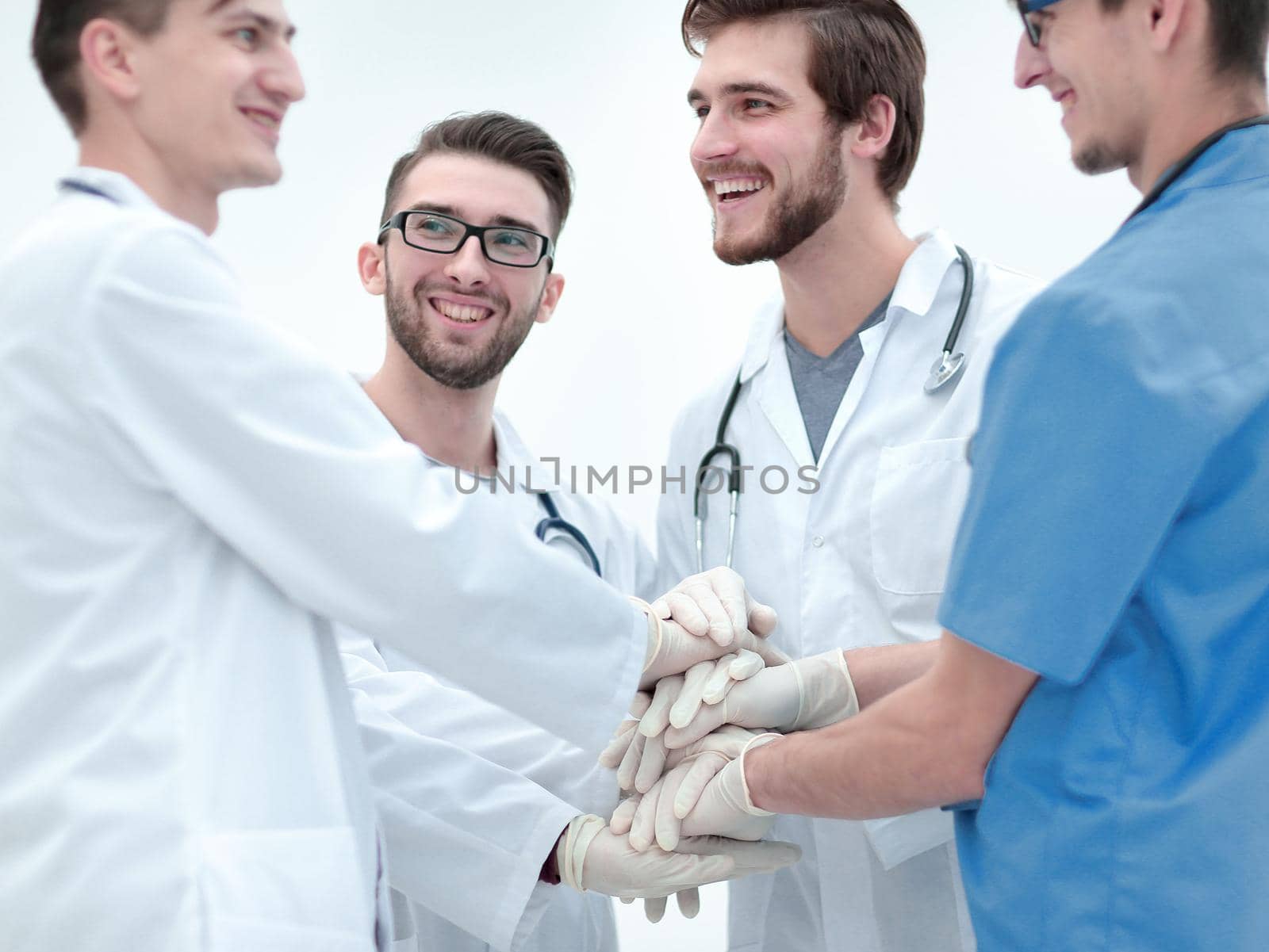 group of doctors,clasped their hands together.the concept of teamwork