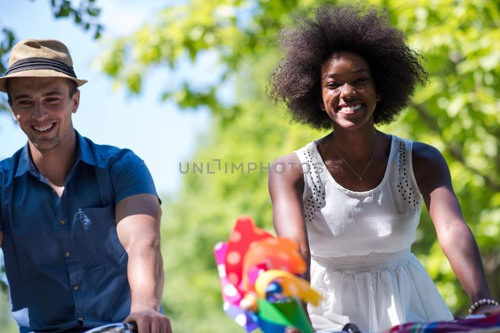 a young man and a beautiful African American girl enjoying a bike ride in nature on a sunny summer day