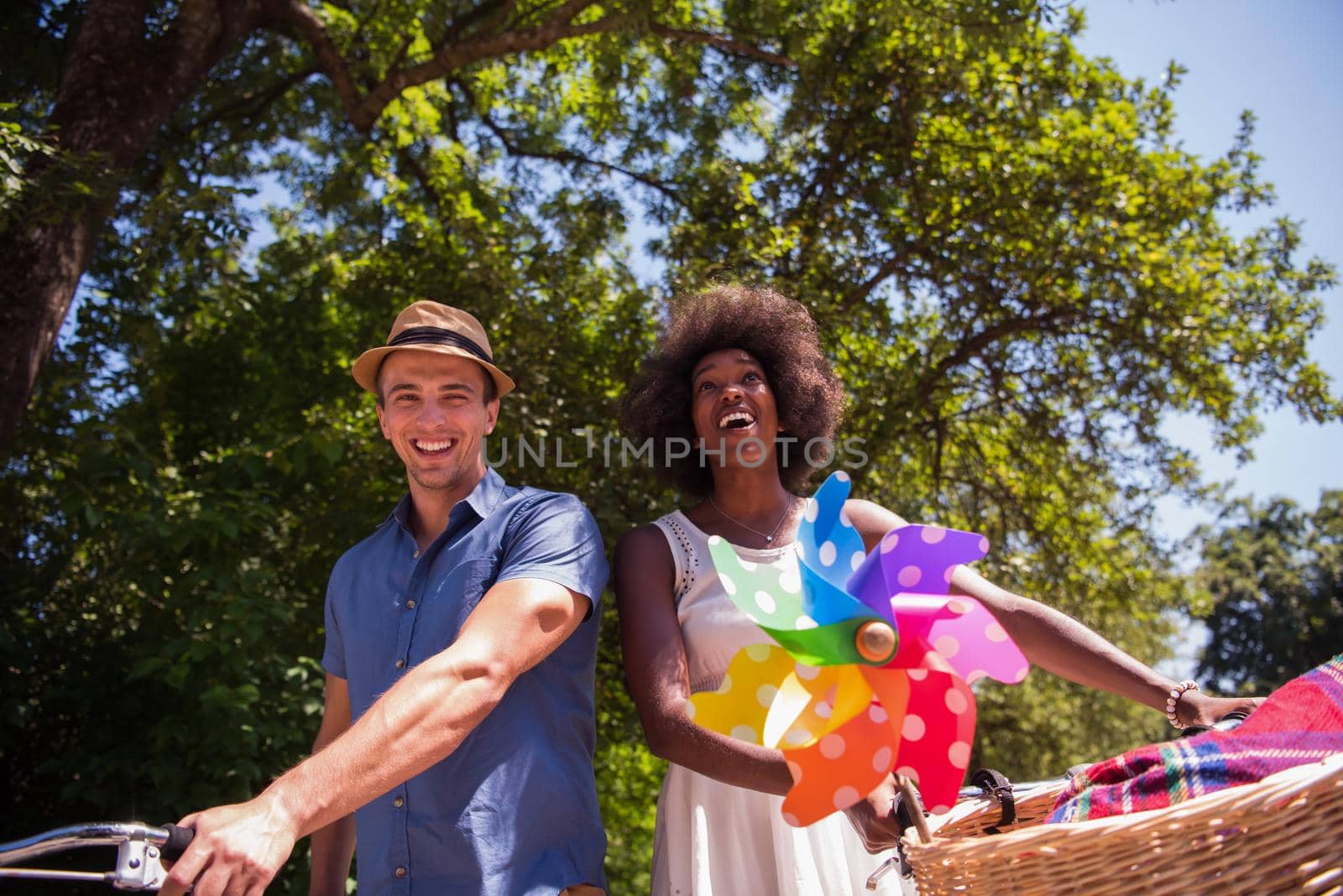 a young man and a beautiful African American girl enjoying a bike ride in nature on a sunny summer day