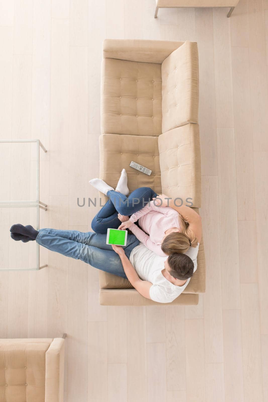 young couple in living room using tablet top view by dotshock