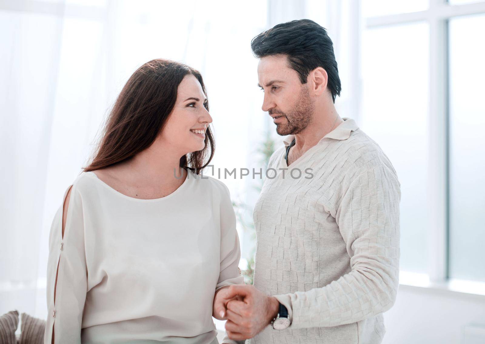 husband and wife standing near the window in the new apartment .the concept of happiness