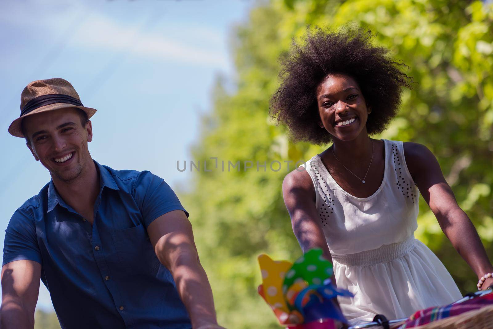 a young man and a beautiful African American girl enjoying a bike ride in nature on a sunny summer day