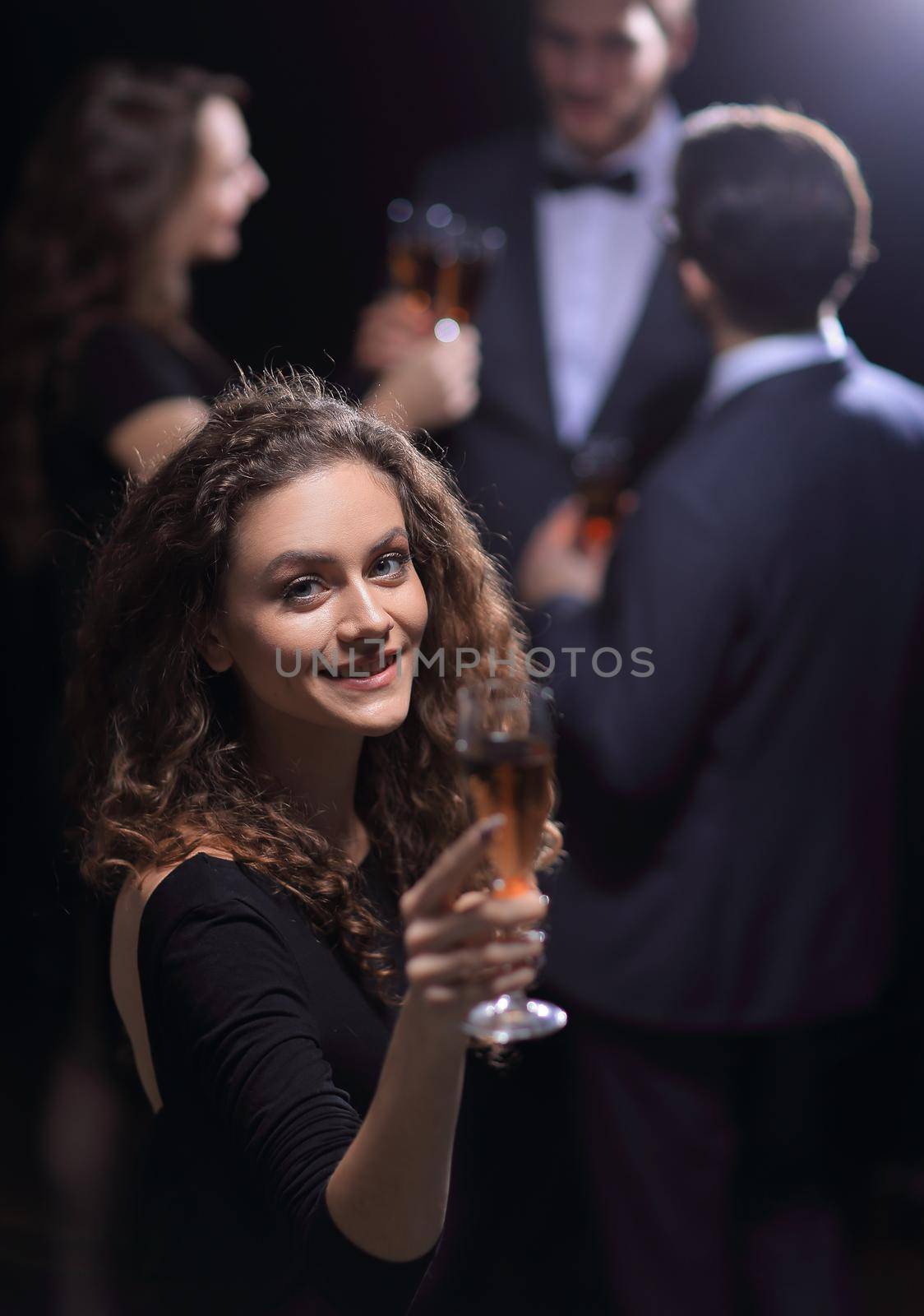 stylish young woman raising a glass of champagne .the holidays and events.