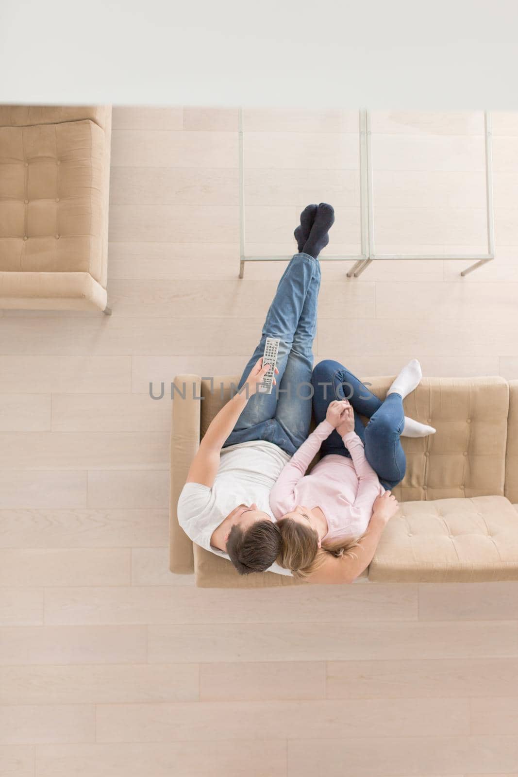 Young couple on the sofa watching television top view by dotshock