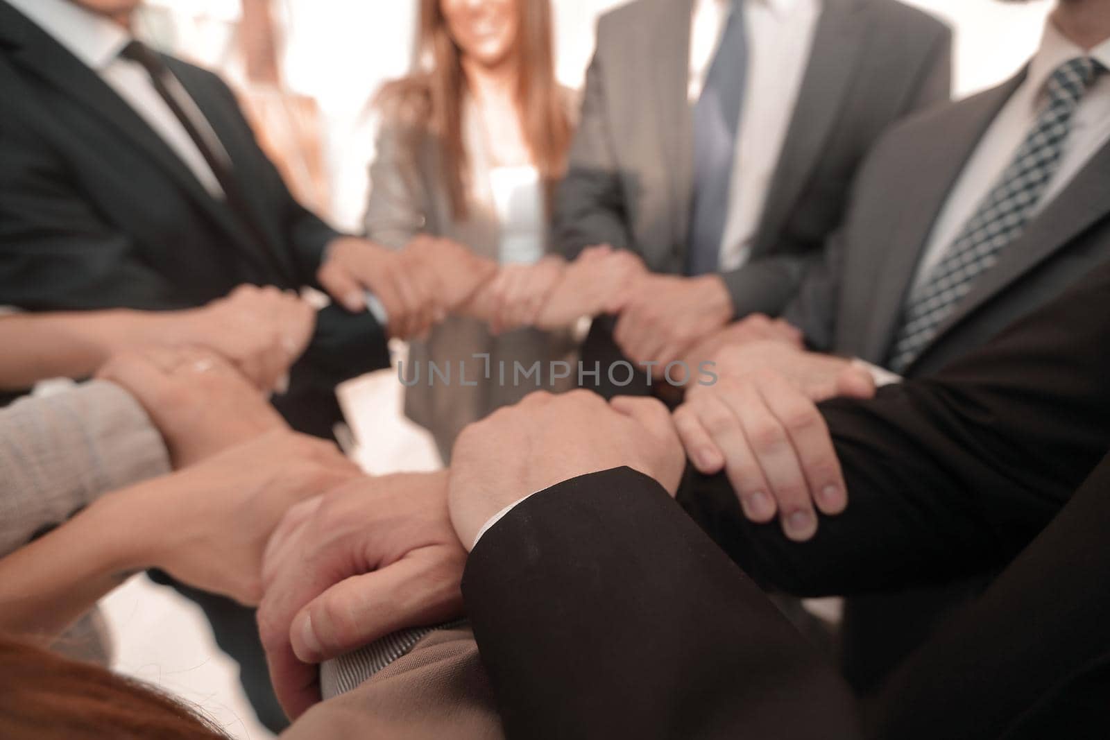 background image of business team folded their hands forming a circle by asdf