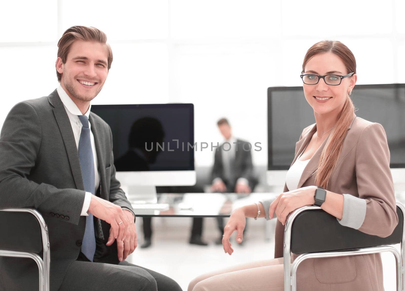 businessman and business woman sitting at office Desk by asdf