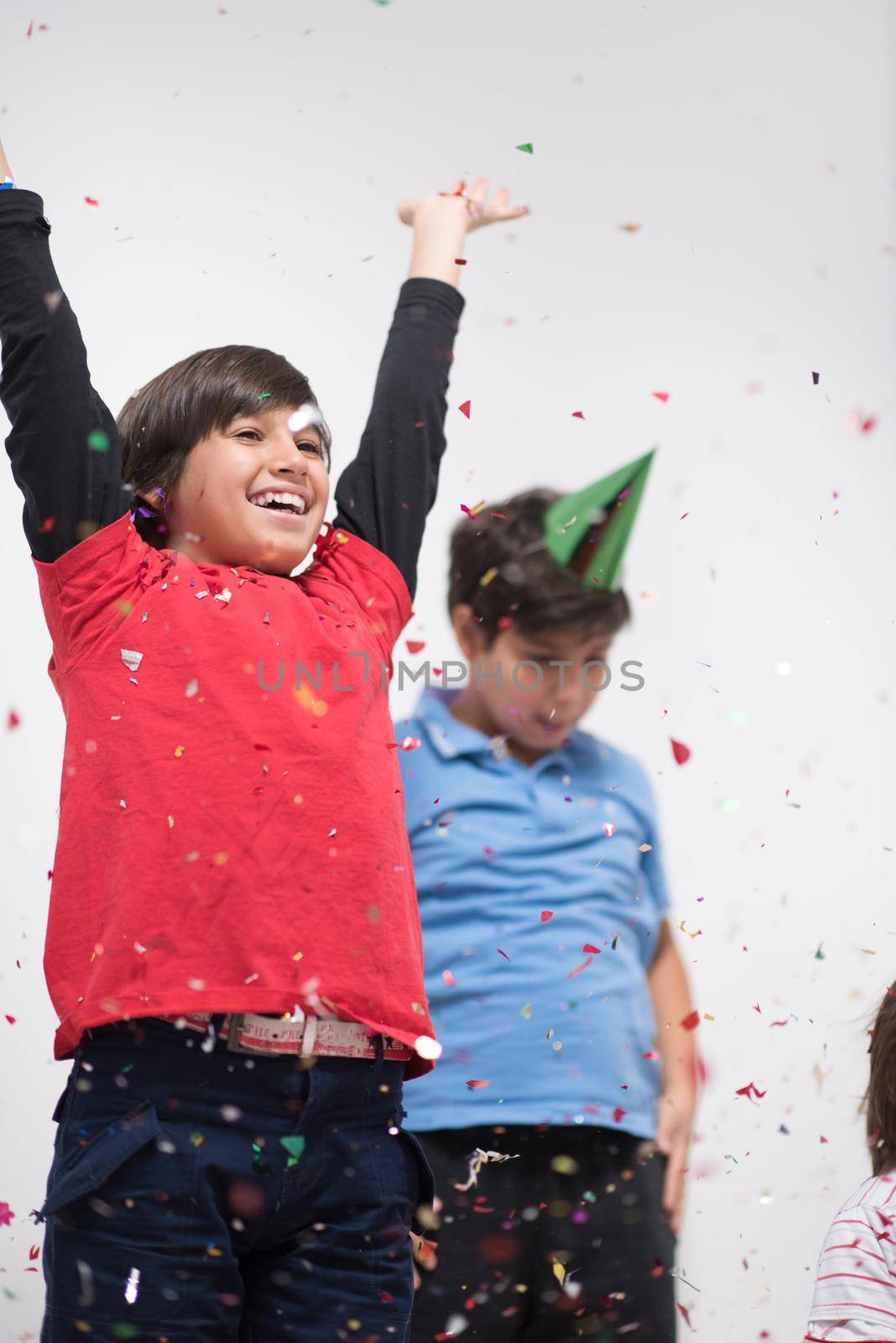 Happy kids celebrating party with blowing confetti