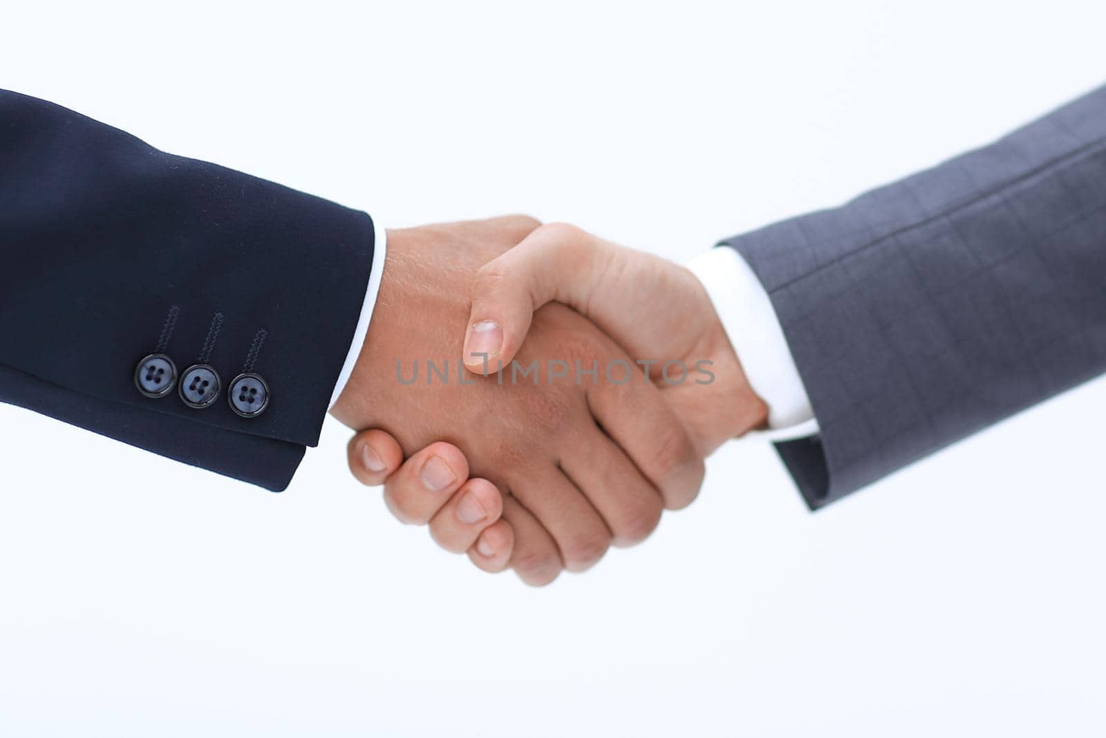 Two young businessman standing opposite each other and shake their hands.