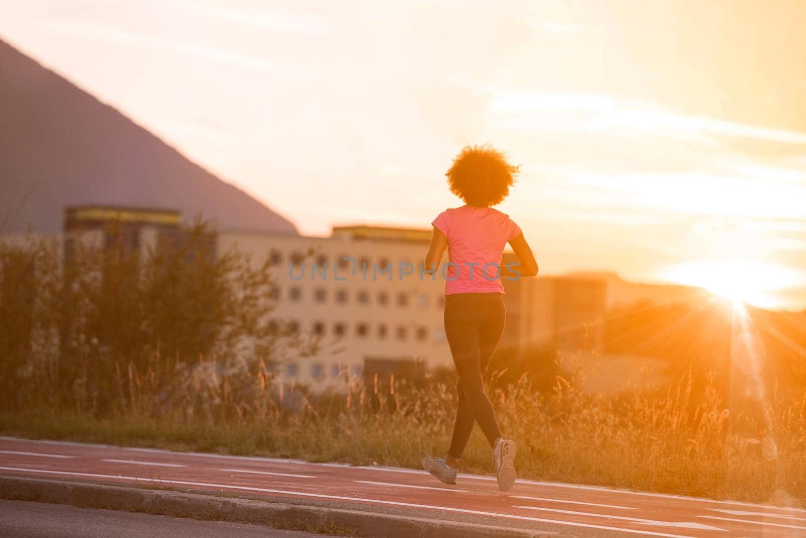 young beautiful African American woman enjoys running outside beautiful summer evening in the city