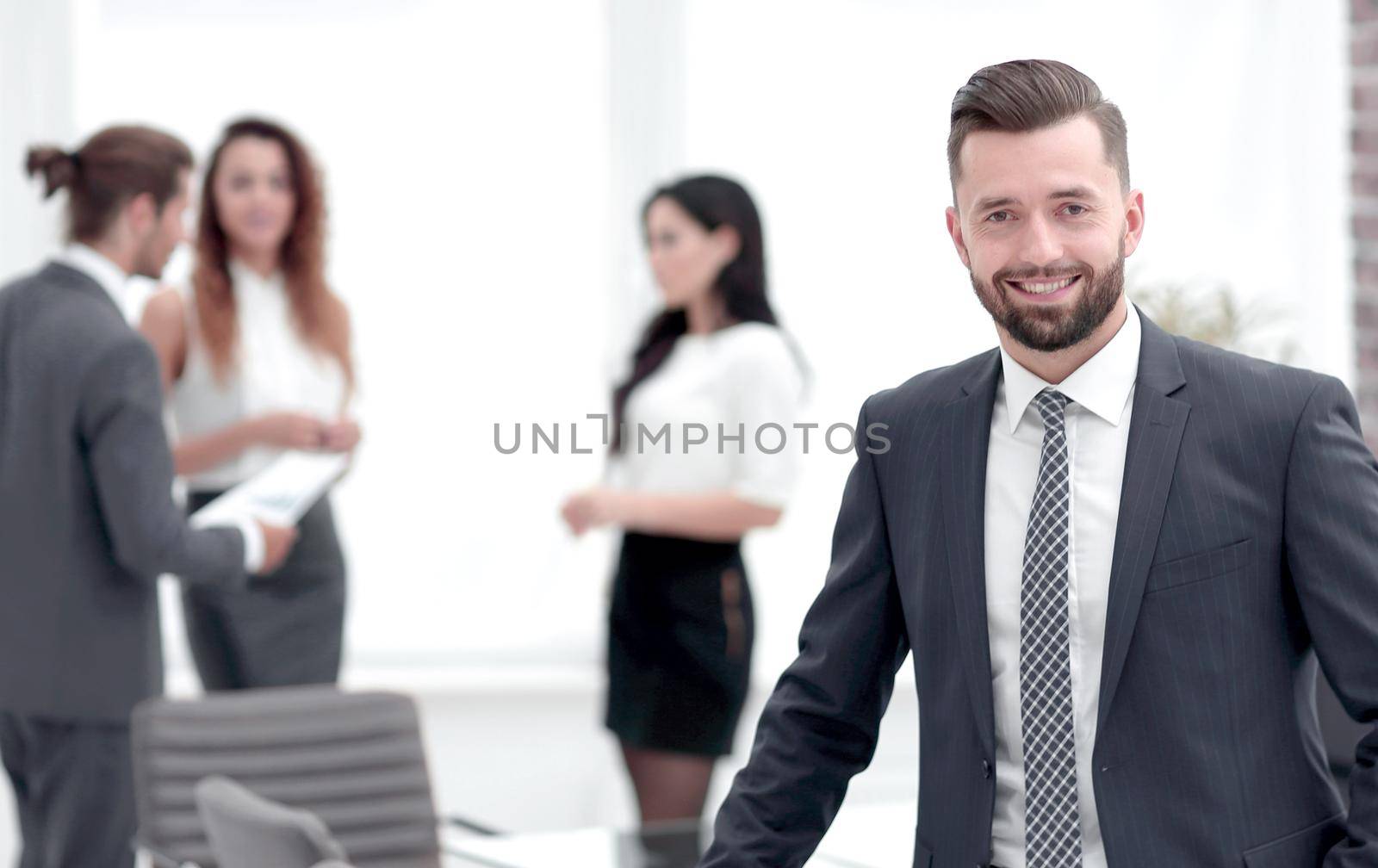 portrait of confident businessman on background of business team.