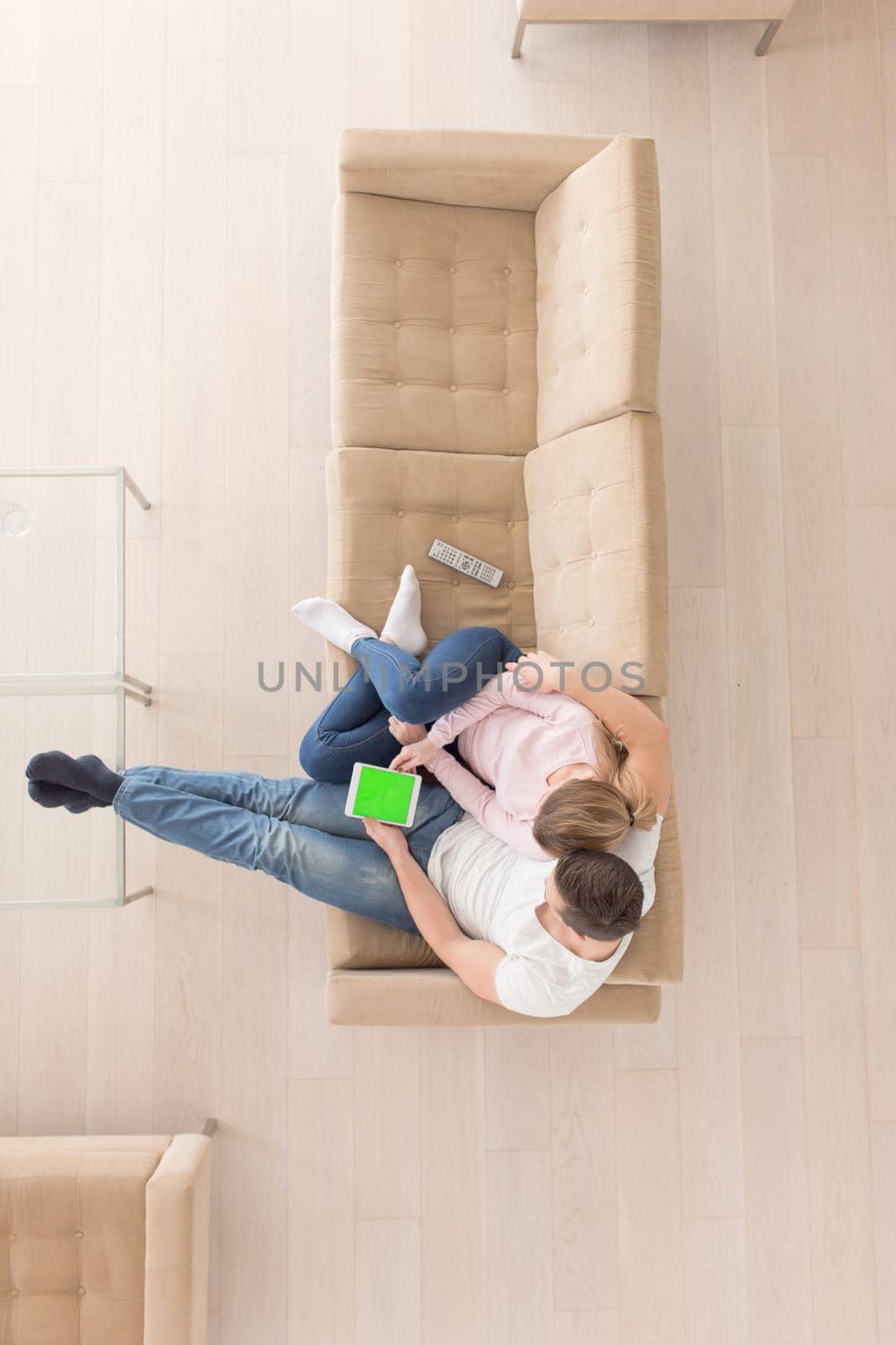 top view of Young couple sitting on a sofa in the luxury living room, using a tablet computer